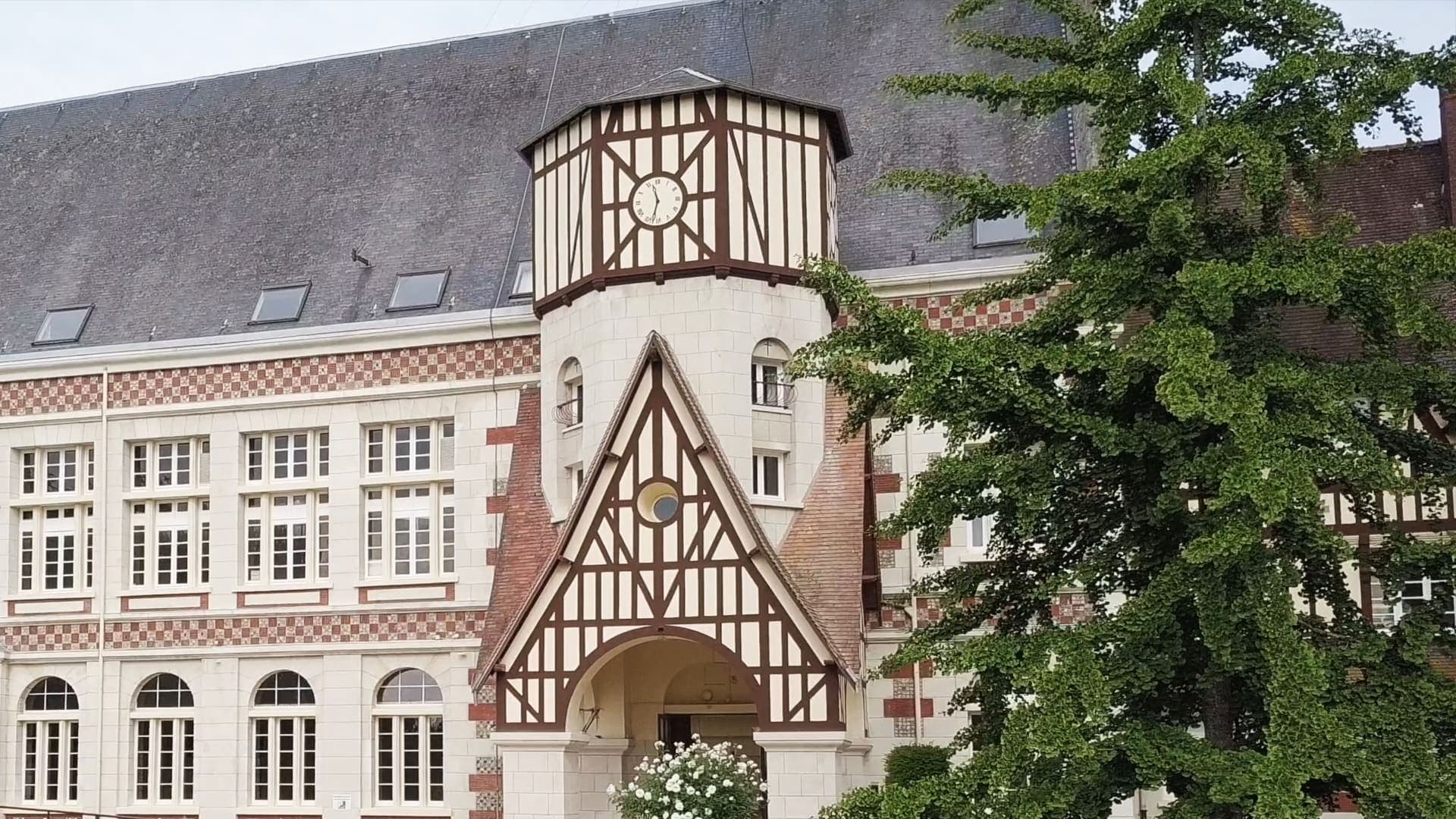 La façade de l’église, sa tour à colombages et son horloge, au-dessus du porche d’entrée.